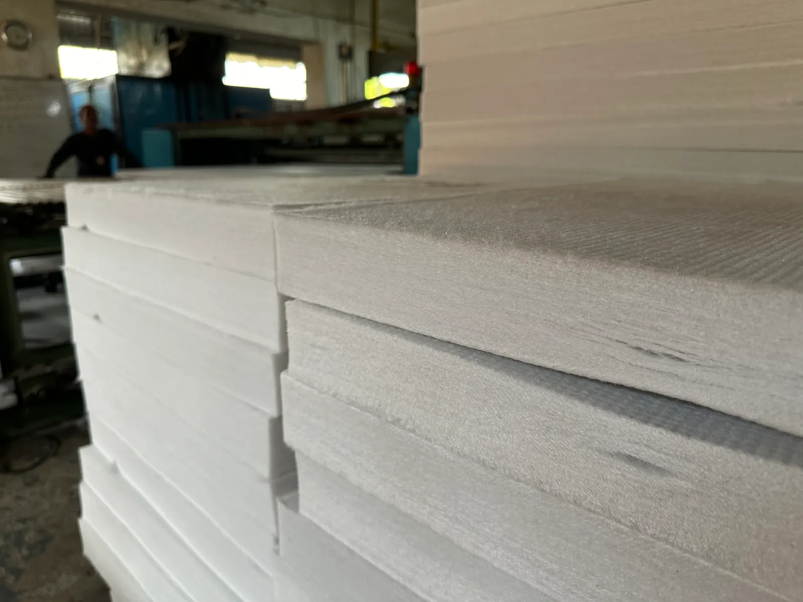 White bonded polyester sheets stacked at the end of the line